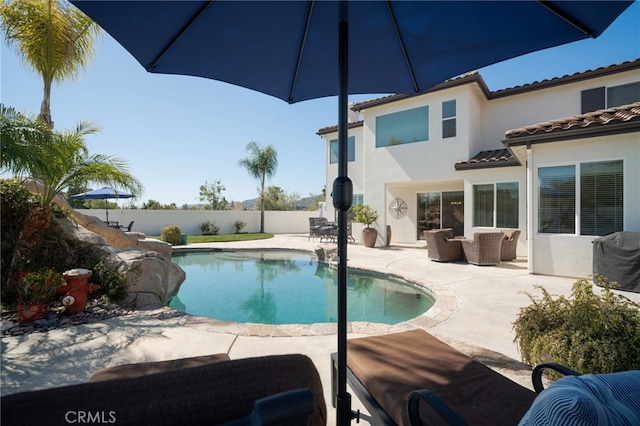 view of swimming pool with outdoor lounge area, a fenced backyard, a fenced in pool, and a patio