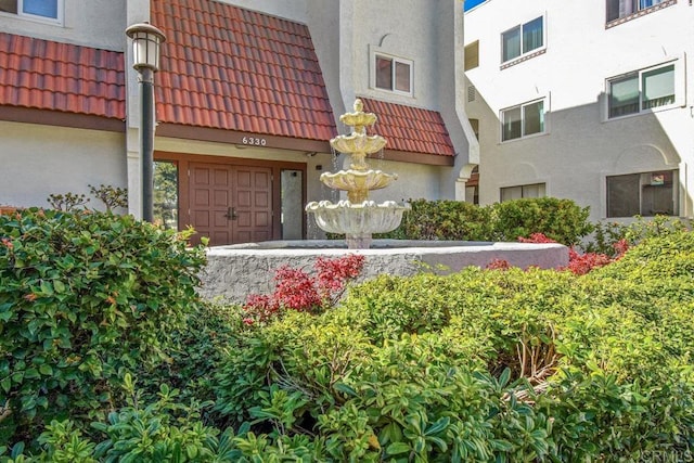 exterior space with stucco siding and a tiled roof