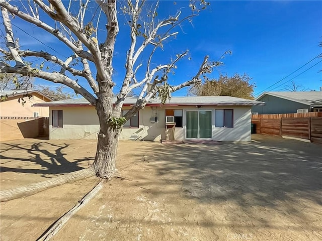 rear view of property with fence and stucco siding