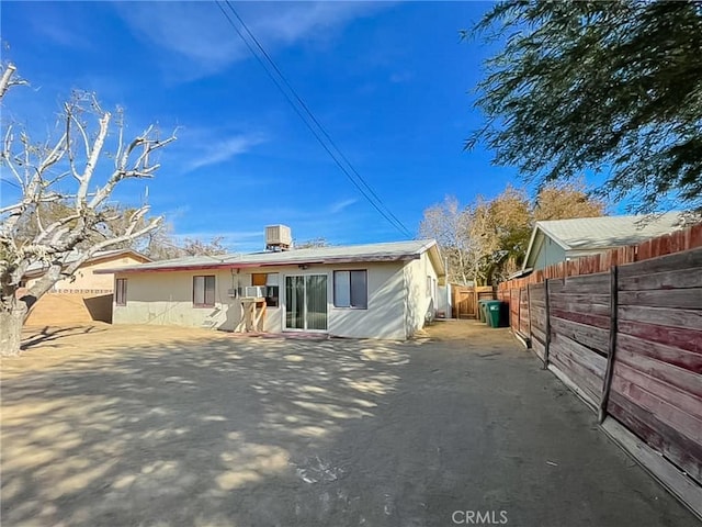 rear view of property featuring a patio and fence