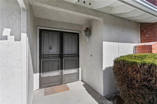 view of exterior entry with stucco siding