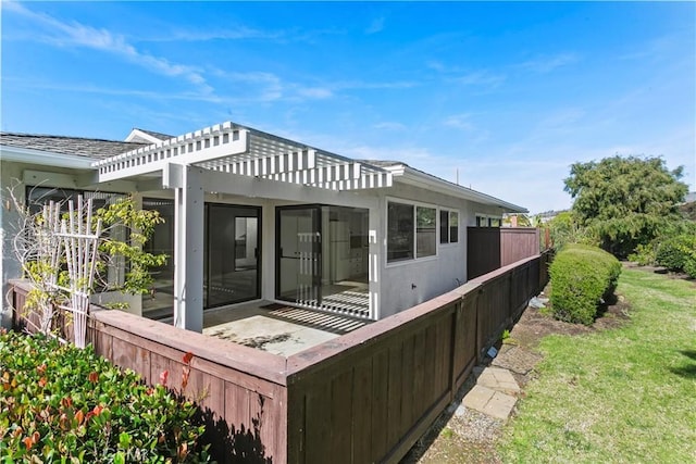 view of home's exterior featuring a lawn, fence, and a pergola