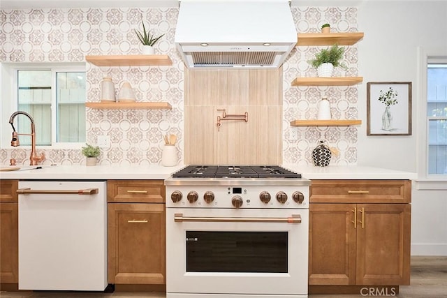 kitchen featuring custom range hood, light countertops, dishwasher, and range with gas cooktop