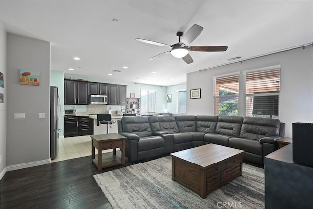 living room with recessed lighting, visible vents, light wood-style floors, a ceiling fan, and baseboards