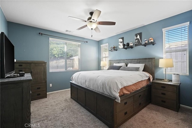 bedroom with baseboards, a ceiling fan, visible vents, and light colored carpet