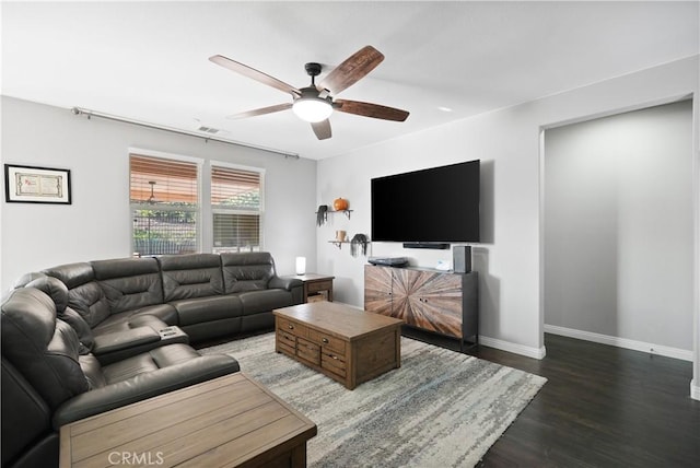 living room featuring a ceiling fan, visible vents, baseboards, and wood finished floors