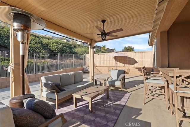 view of patio / terrace featuring outdoor lounge area, a fenced backyard, and a ceiling fan