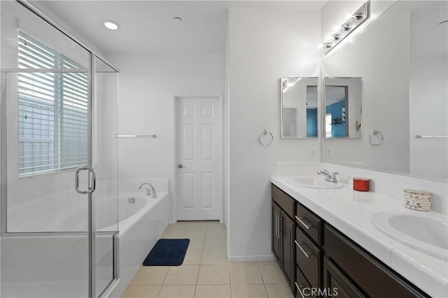 bathroom with double vanity, a stall shower, tile patterned floors, a sink, and a bath