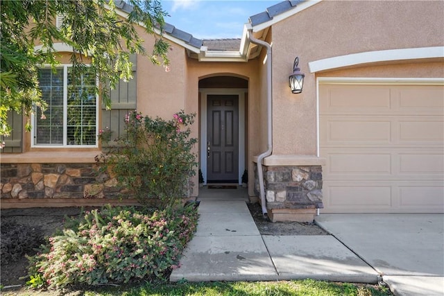 34306 Deergrass Way, Lake Elsinore, CA 92532 - entrance to property with an attached garage, stucco siding, and stone siding