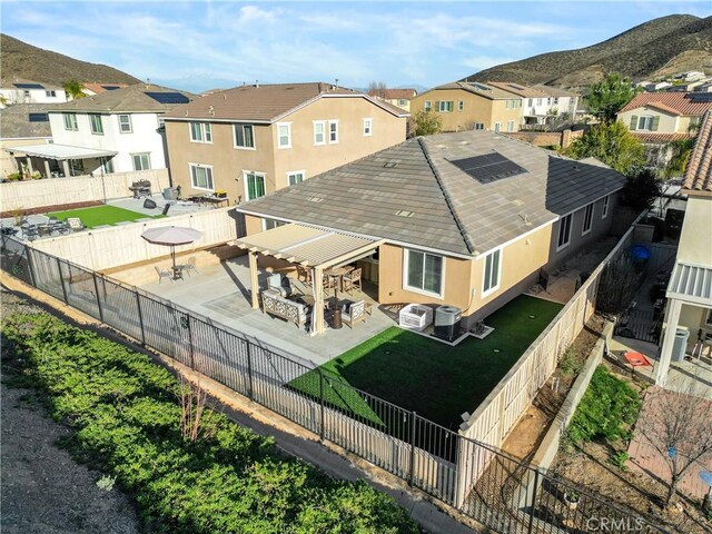 34306 Deergrass Way, Lake Elsinore, CA 92532 - back of property with a residential view, a fenced backyard, a mountain view, central AC unit, and a patio area