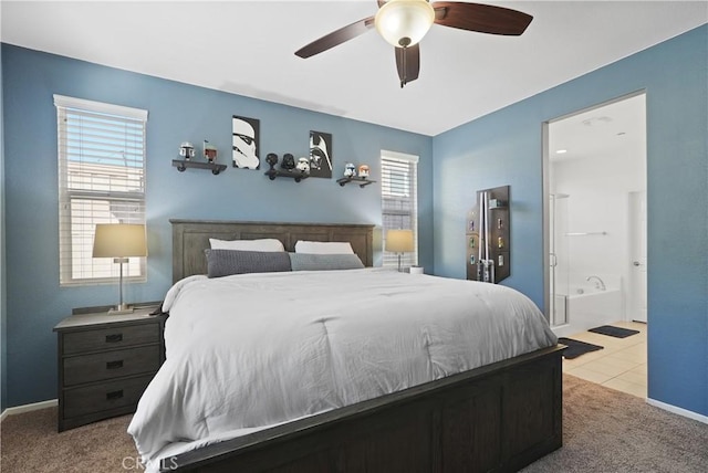 carpeted bedroom with ceiling fan, tile patterned floors, ensuite bath, and baseboards