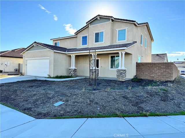 view of front of house featuring an attached garage, driveway, a tile roof, and stucco siding