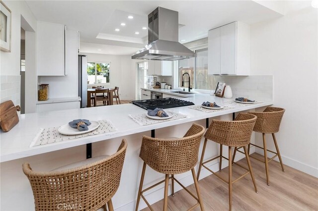 7969 Calle Madrid, Carlsbad, CA 92009 - kitchen with island range hood, a peninsula, a sink, tasteful backsplash, and recessed lighting