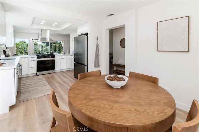 7969 Calle Madrid, Carlsbad, CA 92009 - dining area with light wood finished floors, a raised ceiling, and baseboards