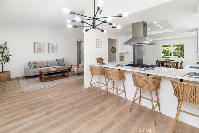 7969 Calle Madrid, Carlsbad, CA 92009 - kitchen with island exhaust hood, light wood-style floors, a breakfast bar, and recessed lighting