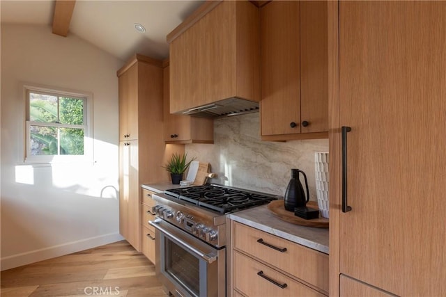 kitchen with stainless steel stove, light countertops, lofted ceiling with beams, light brown cabinetry, and ventilation hood