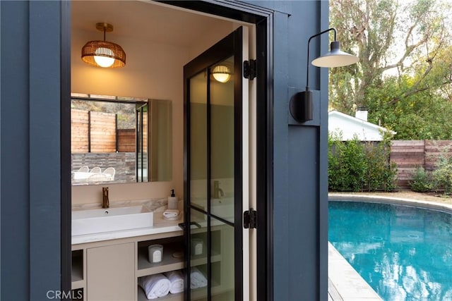 exterior space featuring a sink, fence, and a fenced in pool