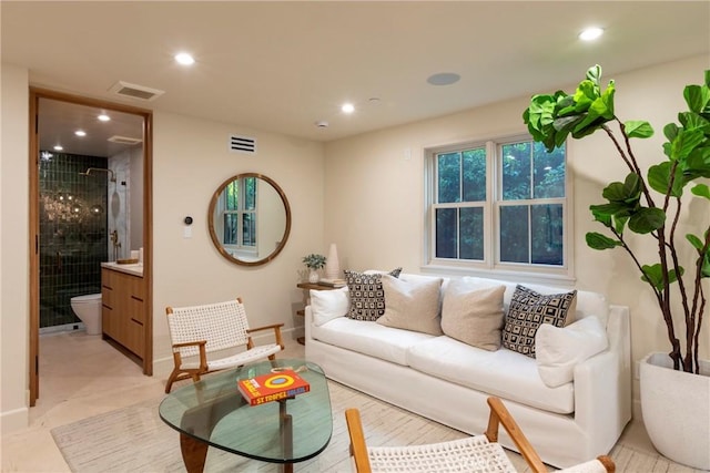 living area with recessed lighting, visible vents, and baseboards