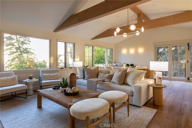 interior space with lofted ceiling with beams, an inviting chandelier, plenty of natural light, and wood finished floors