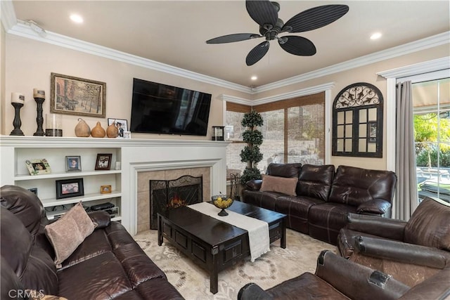 living room featuring ceiling fan, recessed lighting, a tile fireplace, and crown molding