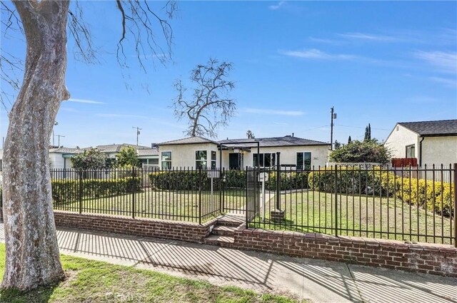 view of front facade with fence private yard, a front lawn, and stucco siding