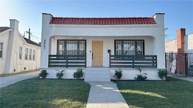 mediterranean / spanish-style house featuring a tiled roof, a porch, a front lawn, and stucco siding