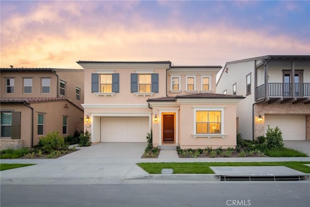 view of front of home with a garage, driveway, and stucco siding