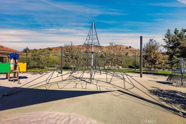 view of sport court with playground community and a mountain view