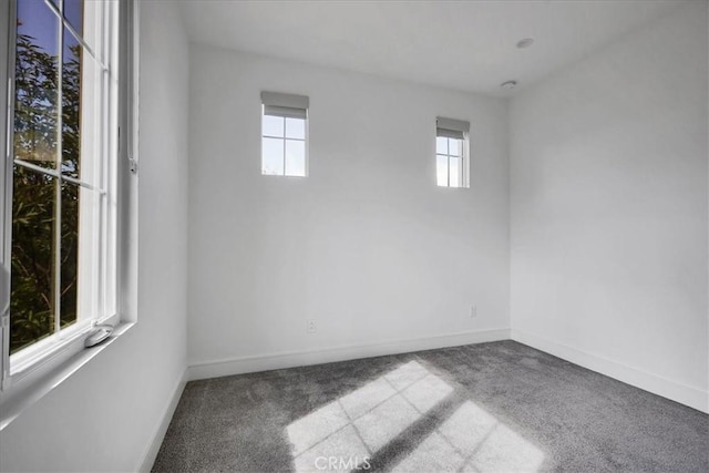 carpeted empty room featuring baseboards