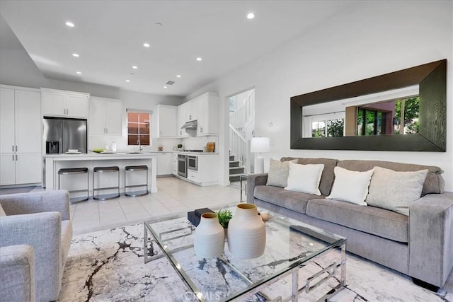 living area featuring light tile patterned floors, stairway, and recessed lighting