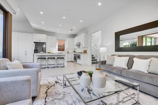 living area with stairs, light tile patterned flooring, and recessed lighting