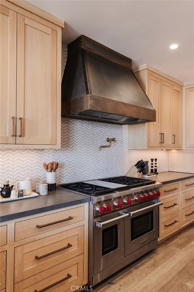 kitchen with custom exhaust hood, decorative backsplash, double oven range, and light brown cabinetry
