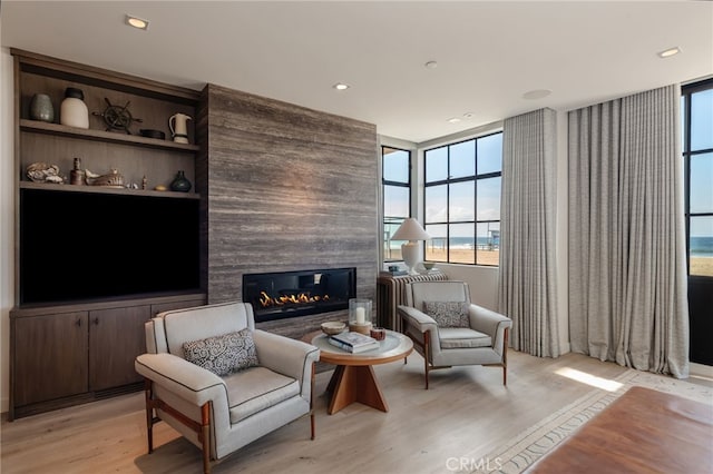 sitting room featuring light wood-type flooring, a fireplace, and recessed lighting