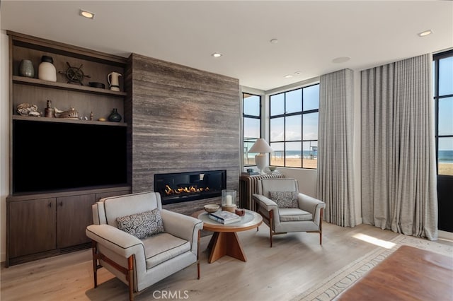 sitting room featuring recessed lighting, a fireplace, and light wood-style flooring