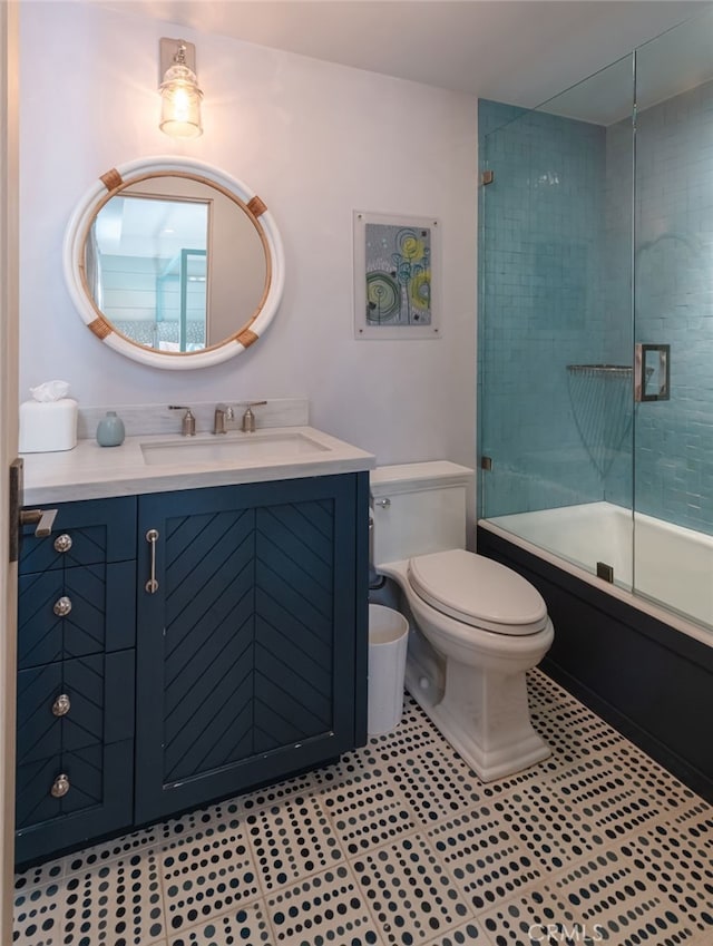 full bathroom with toilet, bath / shower combo with glass door, and vanity