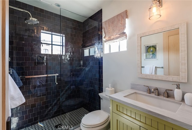 full bath with toilet, vanity, and a shower stall