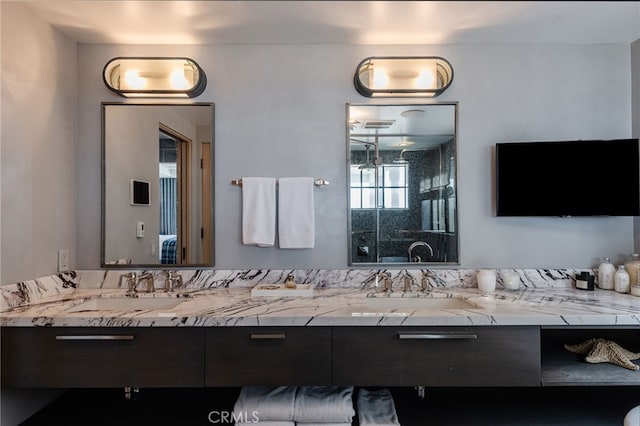 full bathroom featuring a stall shower, double vanity, and a sink