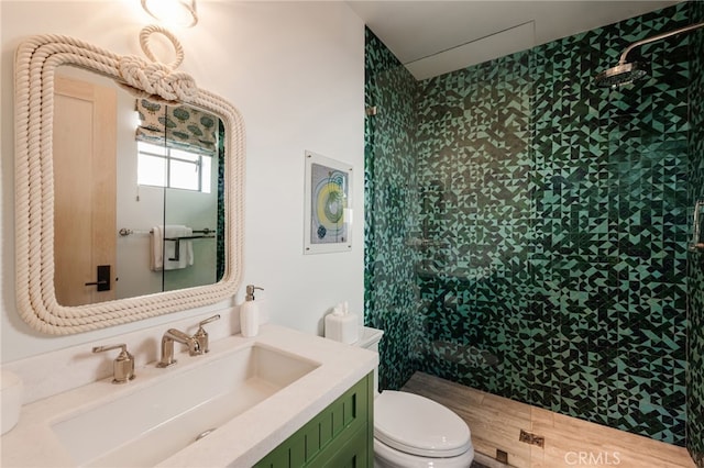 bathroom featuring toilet, vanity, and a shower stall