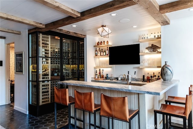 bar with recessed lighting, beam ceiling, and indoor wet bar