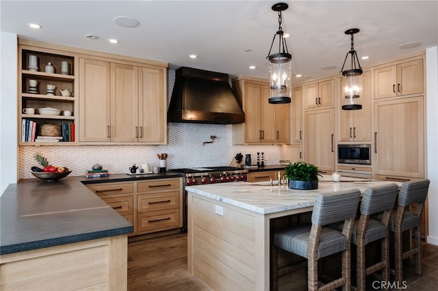 kitchen with light brown cabinets, open shelves, a kitchen breakfast bar, wall chimney exhaust hood, and stainless steel microwave