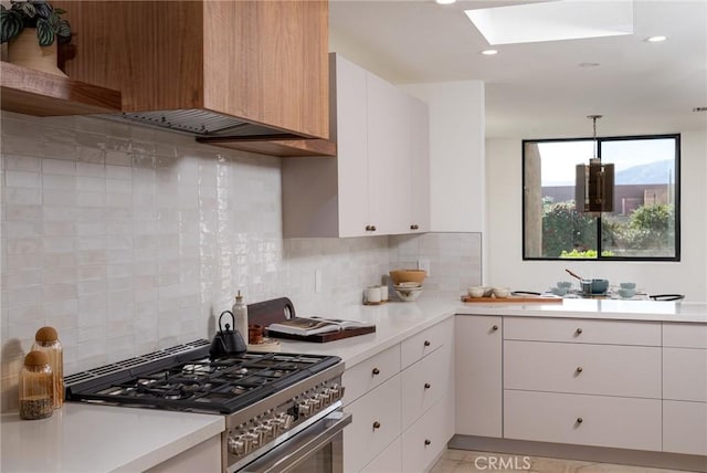 kitchen with high end range, white cabinetry, and light countertops