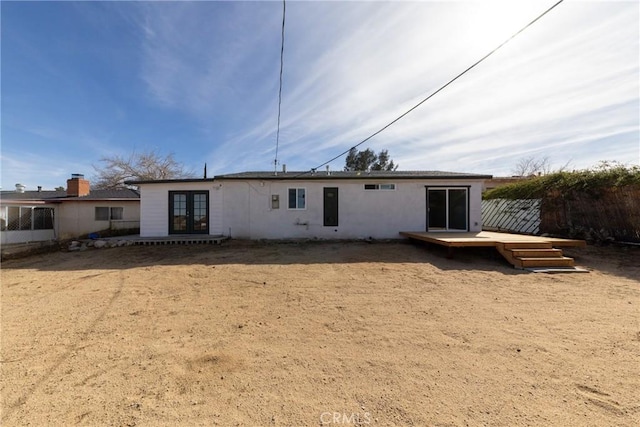 rear view of house featuring french doors, fence, and a wooden deck