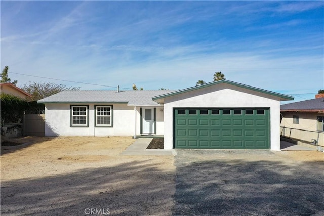 ranch-style house featuring an attached garage and stucco siding