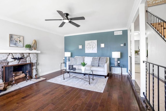 living room with baseboards, visible vents, dark wood finished floors, and crown molding