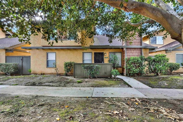 view of property featuring fence and stucco siding