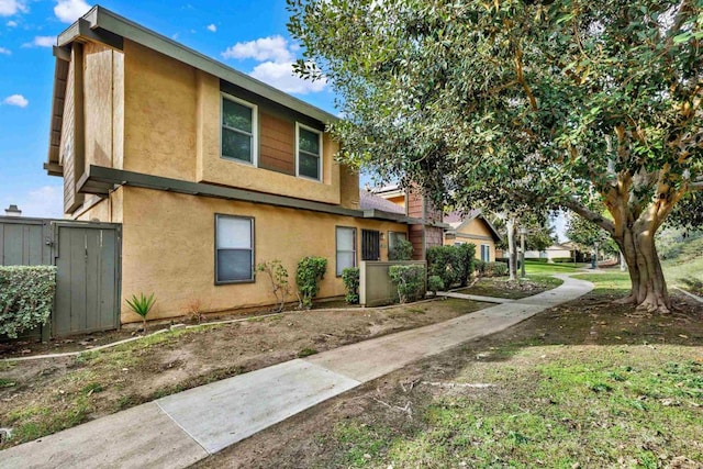 view of home's exterior with fence and stucco siding