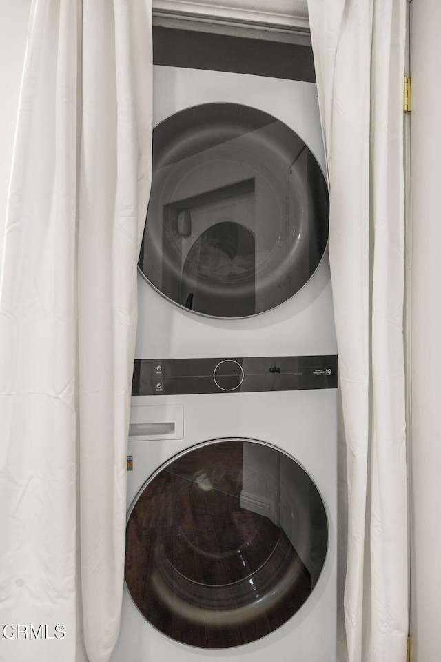 laundry room with stacked washer and dryer and laundry area
