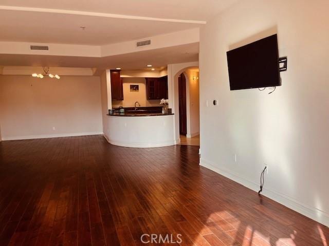 14242 Burbank Blvd Unit 103, Sherman Oaks, CA 91401 - unfurnished living room with arched walkways, a chandelier, dark wood-style floors, baseboards, and a sink