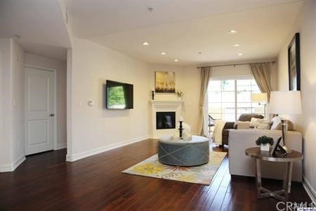 14242 Burbank Blvd Unit 103, Sherman Oaks, CA 91401 - living room featuring wood finished floors, a glass covered fireplace, baseboards, and recessed lighting