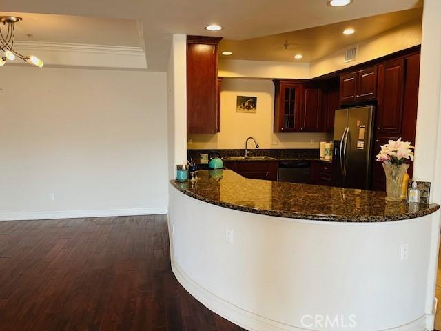 14242 Burbank Blvd Unit 103, Sherman Oaks, CA 91401 - kitchen featuring fridge with ice dispenser, dishwasher, dark stone countertops, dark wood-type flooring, and a peninsula